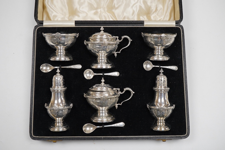 A cased six piece silver condiment set by Finnegans, Ltd, Birmingham, 1940, together with four earlier matched silver condiment spoons by Adie Brothers, 20oz.